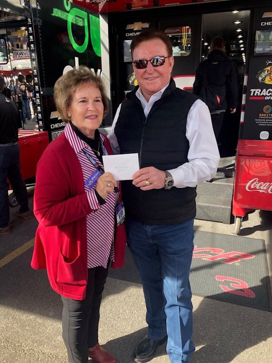 Scruggs’ wife, Dr. Jackie Scruggs Taylor, accepting a check from former NASCAR driver Richard Childress who was supporting the scholarship endowment with his own contribution.