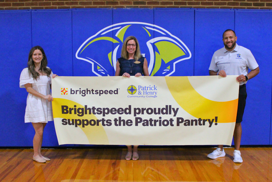 Brightspeed’s Sabrina Anderson presents a sponsorship banner to P&HCC’s Tiffani Underwood, Associate Vice President of Institutional Advancement/P&HCC Foundation Executive Director, and Brandon Johnson, Director of Athletics & Student Engagement.